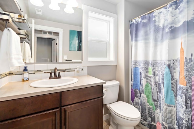 full bath with toilet, vanity, backsplash, and visible vents