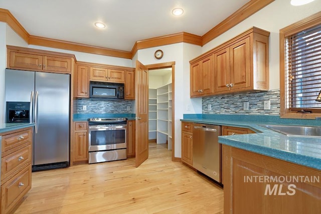 kitchen with decorative backsplash, appliances with stainless steel finishes, and crown molding