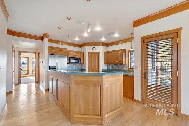 kitchen with decorative backsplash, stainless steel fridge with ice dispenser, a kitchen island, and pendant lighting