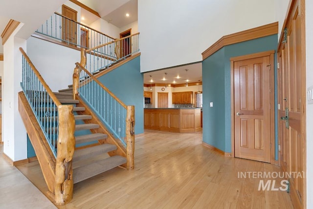 stairway with hardwood / wood-style flooring and a high ceiling