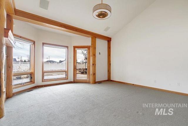 carpeted empty room with vaulted ceiling