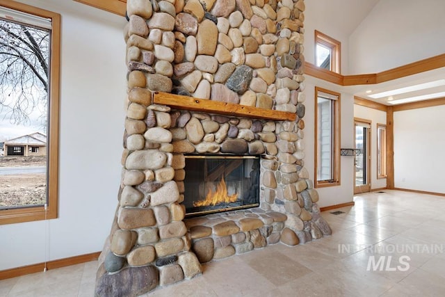 unfurnished living room with a fireplace, light tile patterned floors, and high vaulted ceiling