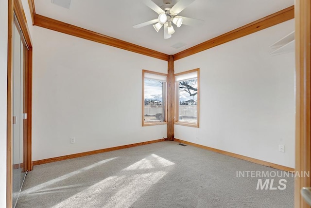 spare room with carpet flooring, ceiling fan, and ornamental molding