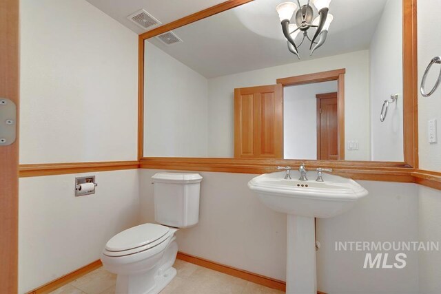 bathroom featuring a chandelier, toilet, and sink