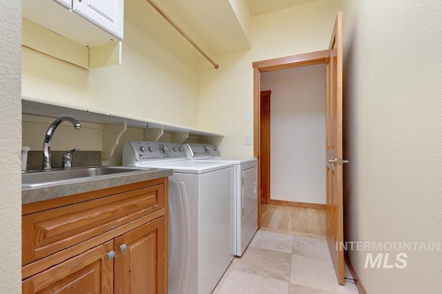 washroom featuring cabinets, washer and dryer, and sink