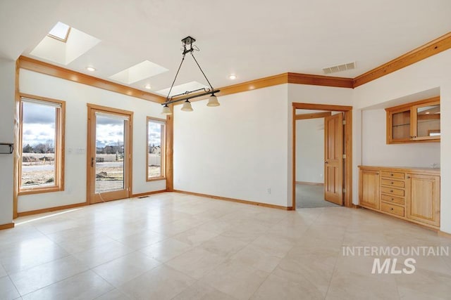 unfurnished dining area featuring a skylight and crown molding