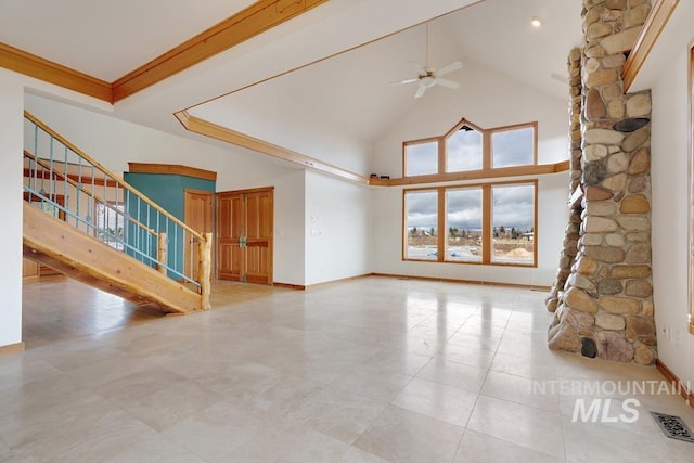 unfurnished living room featuring ceiling fan, ornamental molding, and a high ceiling