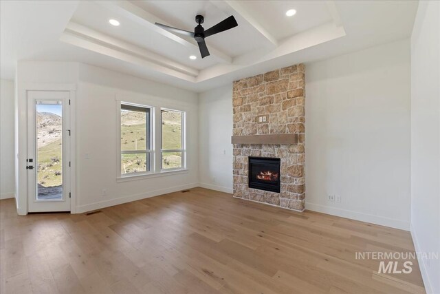 6535 S Evie Way, Eagle, ID 83714 - unfurnished living room featuring healthy amount of natural light, light wood-type flooring, a raised ceiling, a ceiling fan, and recessed lighting