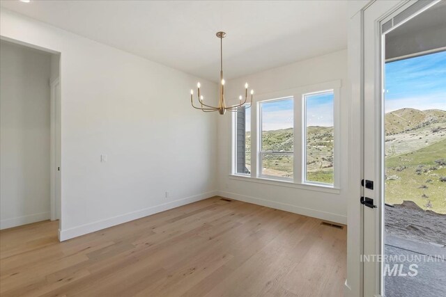 6535 S Evie Way, Eagle, ID 83714 - unfurnished dining area featuring baseboards, light wood-style flooring, and a chandelier