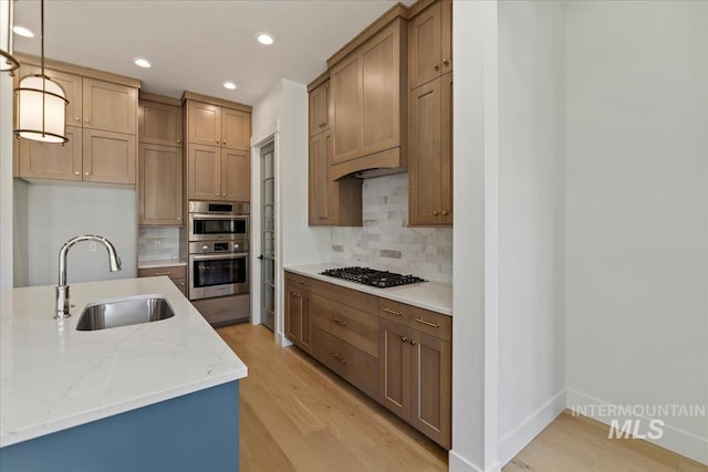 6535 S Evie Way, Eagle, ID 83714 - kitchen with a sink, light wood-style flooring, decorative backsplash, light stone countertops, and recessed lighting