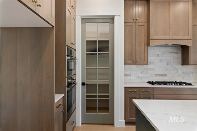 6535 S Evie Way, Eagle, ID 83714 - kitchen featuring tasteful backsplash, light stone countertops, gas cooktop, and light wood-style floors