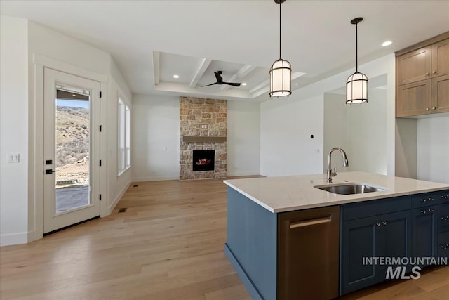 6535 S Evie Way, Eagle, ID 83714 - kitchen with a sink, light wood-style flooring, a ceiling fan, a stone fireplace, and decorative light fixtures