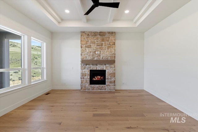 6535 S Evie Way, Eagle, ID 83714 - unfurnished living room with light wood-style floors, ceiling fan, a stone fireplace, beamed ceiling, and recessed lighting