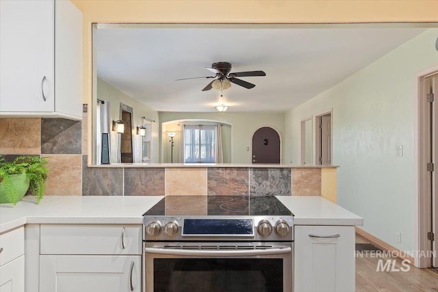 120 W Main St, Hagerman, ID 83332 - kitchen featuring light hardwood / wood-style floors, white cabinetry, electric stove, and backsplash