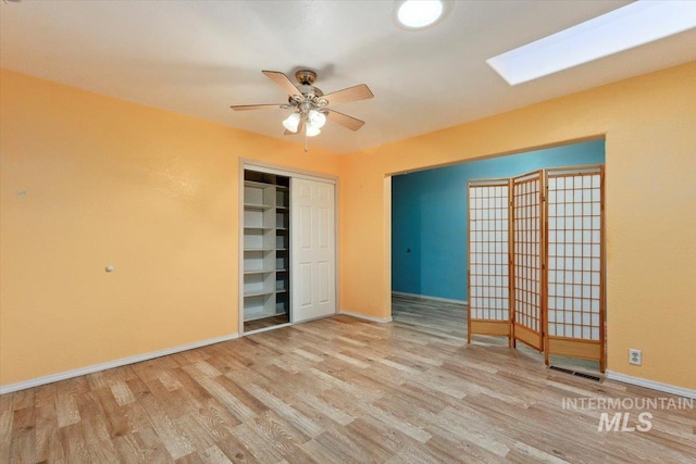 120 W Main St, Hagerman, ID 83332 - unfurnished bedroom with a skylight, ceiling fan, a closet, and light hardwood / wood-style floors