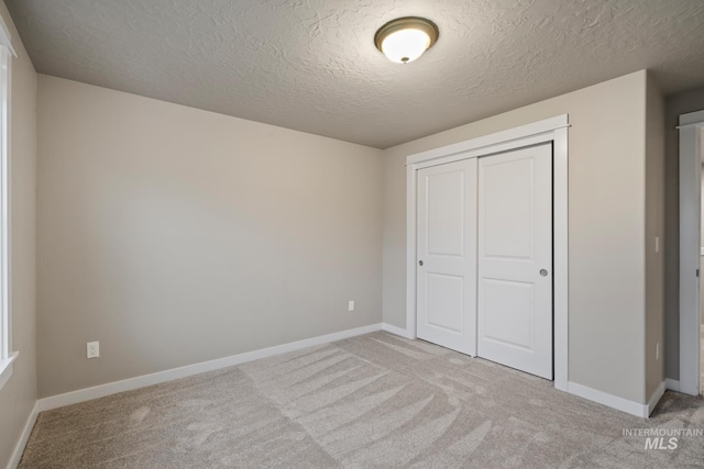 10449 W Thimbleberry Dr, Star, ID 83669 - unfurnished bedroom with light colored carpet, a closet, and a textured ceiling