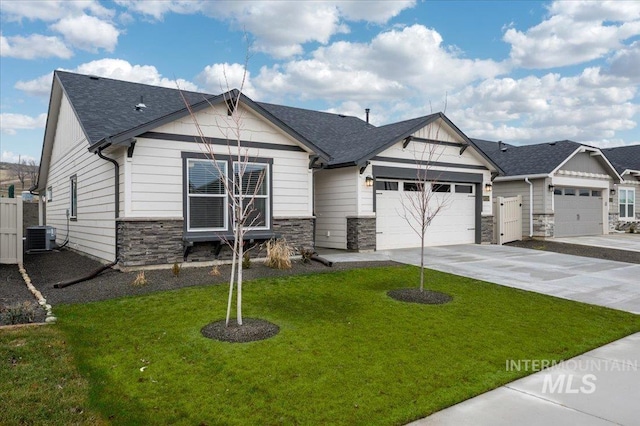 view of front of property with central AC unit, a garage, and a front lawn