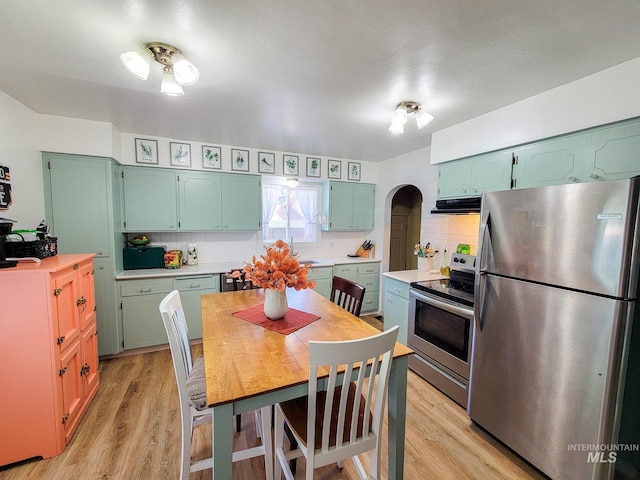921 14th St, Lewiston, ID 83501 - kitchen with appliances with stainless steel finishes, extractor fan, arched walkways, and light countertops