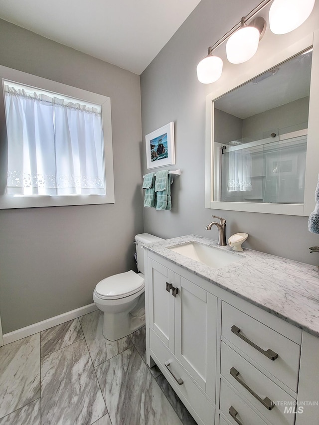 921 14th St, Lewiston, ID 83501 - bathroom with marble look tile flooring, vanity, toilet, baseboards, and a shower