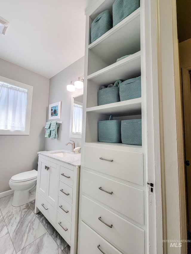 921 14th St, Lewiston, ID 83501 - bathroom featuring vanity, plenty of natural light, marble look tiles, and toilet