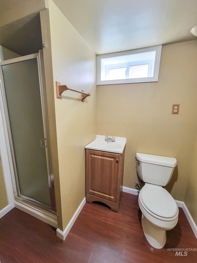 921 14th St, Lewiston, ID 83501 - bathroom featuring wood finished floors, a sink, a shower stall, toilet, and baseboards