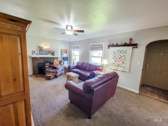 921 14th St, Lewiston, ID 83501 - carpeted living area with a ceiling fan, arched walkways, baseboards, and a fireplace