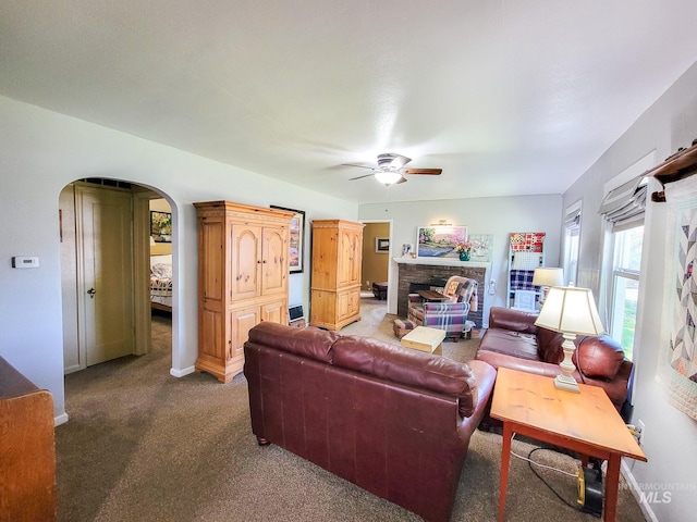 921 14th St, Lewiston, ID 83501 - living room with carpet, a ceiling fan, arched walkways, a fireplace, and baseboards
