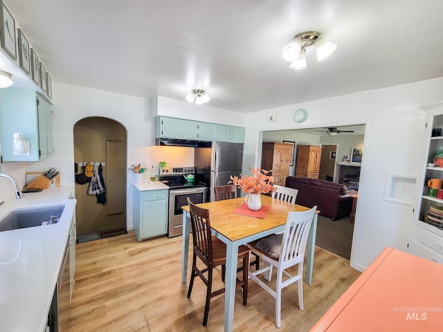 921 14th St, Lewiston, ID 83501 - dining room featuring a ceiling fan, arched walkways, light wood-style floors, and a fireplace
