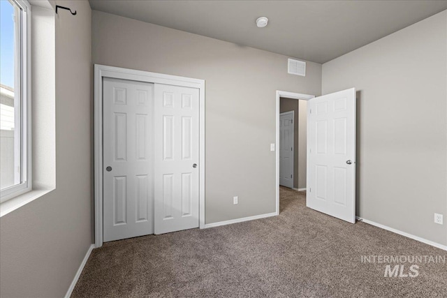 unfurnished bedroom featuring carpet floors and a closet