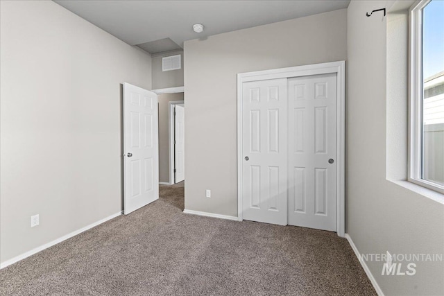 unfurnished bedroom featuring carpet flooring and a closet