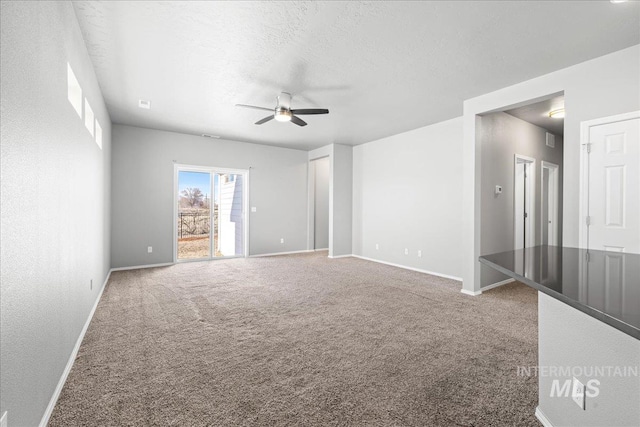 carpeted spare room featuring ceiling fan and a textured ceiling