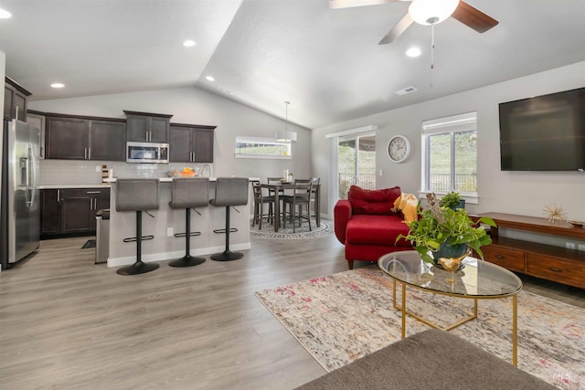 living area featuring lofted ceiling, light wood-style floors, recessed lighting, a ceiling fan, and baseboards