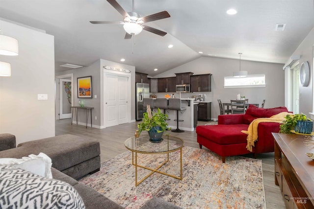 living area with vaulted ceiling, ceiling fan, light wood finished floors, baseboards, and recessed lighting