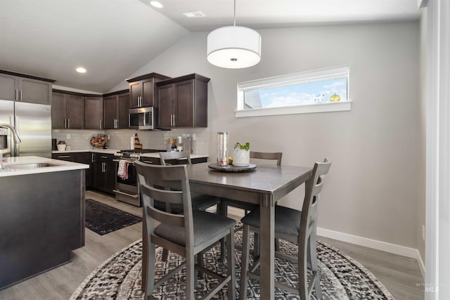 dining space with vaulted ceiling, light wood-type flooring, baseboards, and recessed lighting