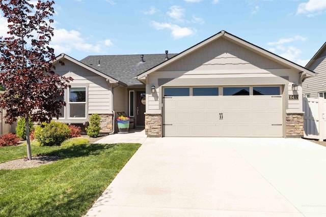 view of front of house with stone siding, a garage, and driveway
