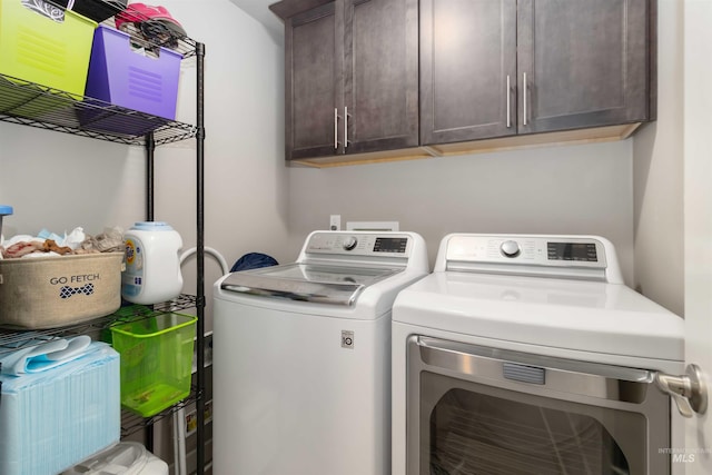 laundry area featuring washing machine and clothes dryer and cabinet space