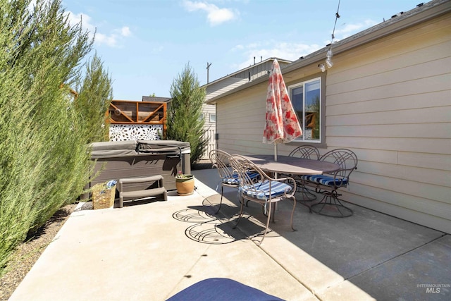 view of patio featuring a hot tub and outdoor dining area