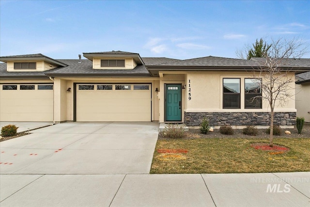 prairie-style house with stucco siding, stone siding, a garage, and driveway