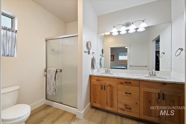 bathroom with a healthy amount of sunlight, wood finished floors, and a sink