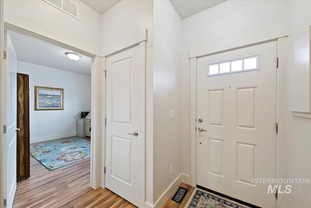 entryway featuring visible vents, light wood-type flooring, and baseboards