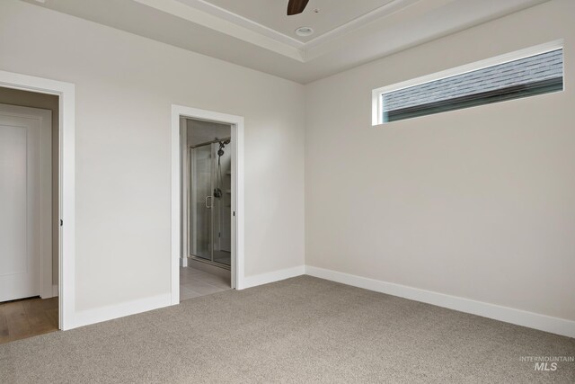 unfurnished bedroom featuring light carpet, ensuite bath, and ceiling fan