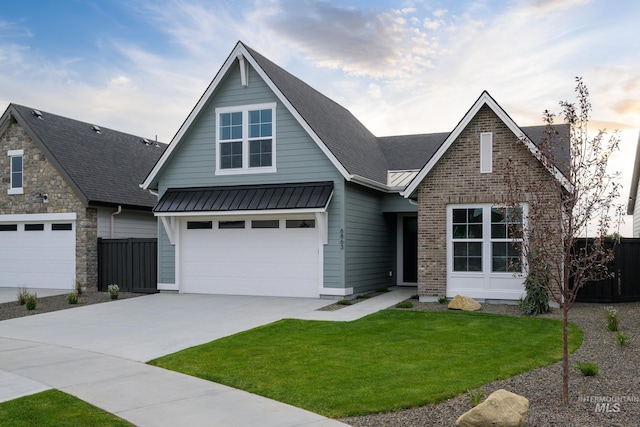 view of front of home with a garage and a lawn