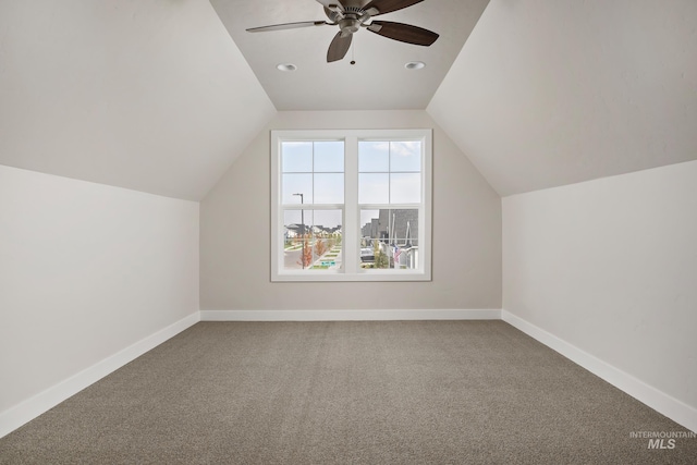 additional living space featuring carpet floors, vaulted ceiling, and ceiling fan