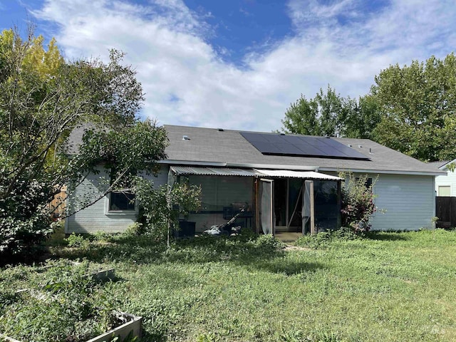 14285 Shenandoah St, Caldwell, ID 83607 - back of house with roof mounted solar panels, a yard, and a shingled roof