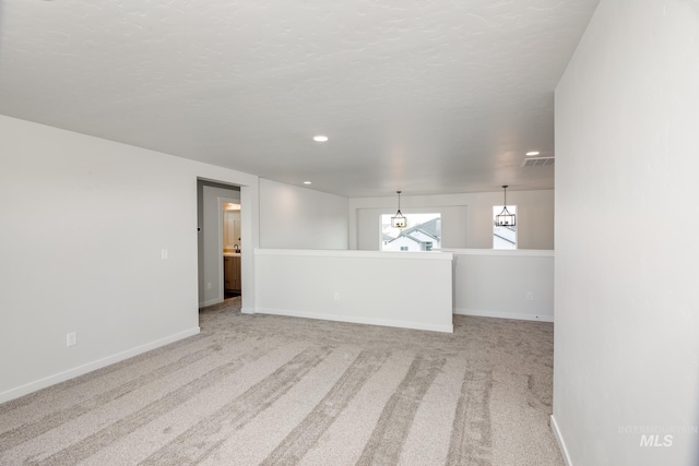 carpeted empty room featuring visible vents, baseboards, and a textured ceiling