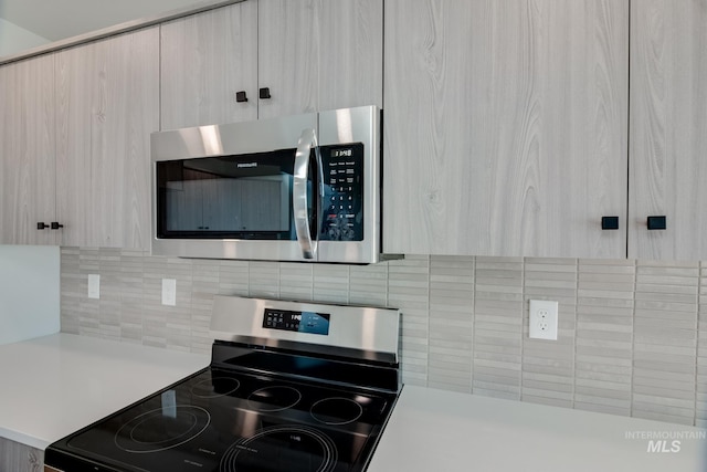 kitchen featuring tasteful backsplash, appliances with stainless steel finishes, and light countertops