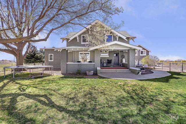 133 N Rd, Jerome, ID 83338 - back of house with fence, a yard, stucco siding, a patio area, and a trampoline