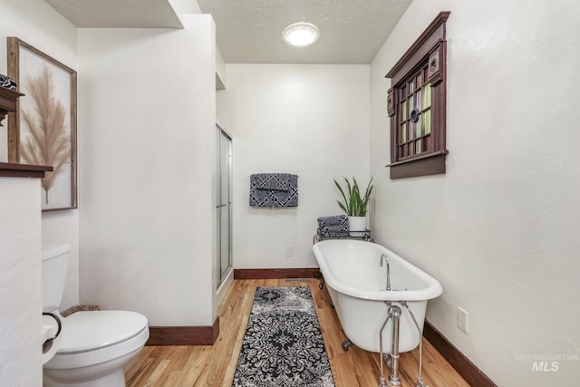 133 N Rd, Jerome, ID 83338 - bathroom with a soaking tub, toilet, baseboards, wood finished floors, and a shower stall