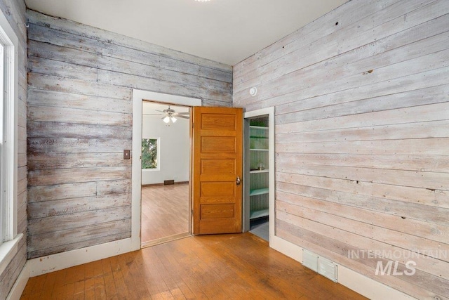 1045 N Beech Rd, Genesee, ID 83832 - spare room with wooden walls, visible vents, and hardwood / wood-style flooring