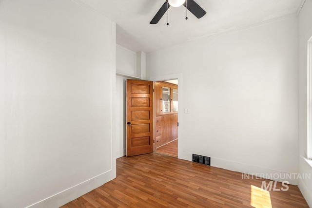 1045 N Beech Rd, Genesee, ID 83832 - spare room featuring wood finished floors, a ceiling fan, crown molding, visible vents, and baseboards